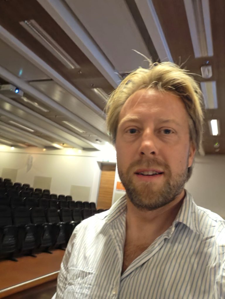 Remy Steijger in een collegezaal van Hogeschool Inholland.